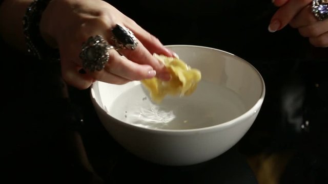 Divination with candle. woman pouring wax into the water. 