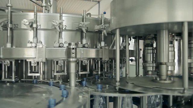 Rotating machines are moving bottles and pouring water