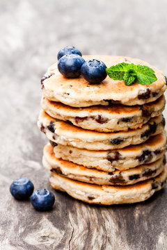 Stack  of welsh cakes with blueberry and mint leaves on wooden b