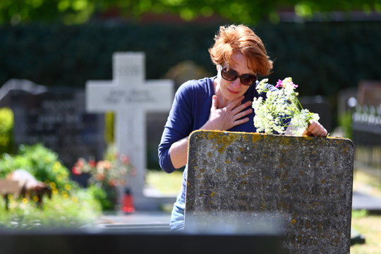 mourning/ woman mourning a deceased loved one on a graveyard