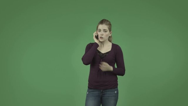 attractive casual caucasian girl isolated on green upset on cell phone