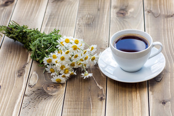 Coffee cup with White flower decoration on wooden table