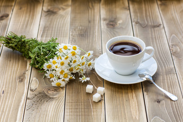 Coffee cup with White flower decoration on wooden table