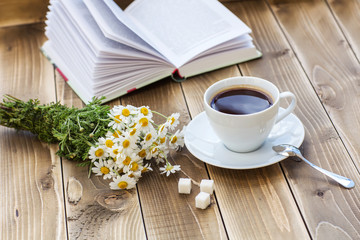 Coffee cup with White flower decoration on wooden table