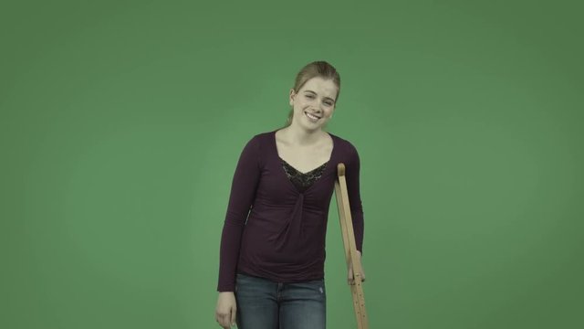 attractive casual caucasian girl isolated on green confident with crutch