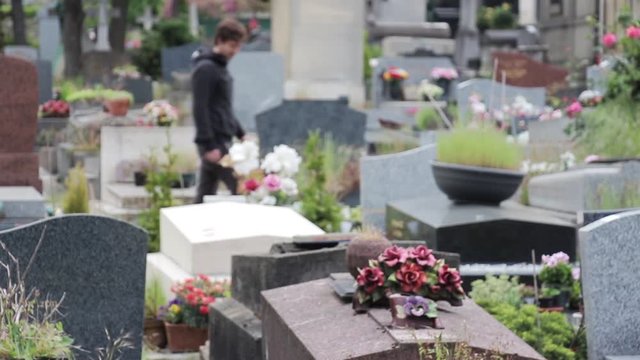Young Man Arrives In The Cemetery. Man arrives and starts praying In the Tombstone of a Cemetery