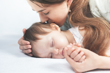 Obraz na płótnie Canvas Mother kissing a baby. Care concept