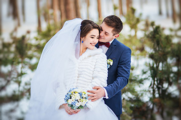 Happy bride and groom in winter day on their wedding
