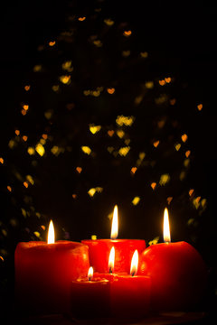 Red candles burning with bokeh lights
