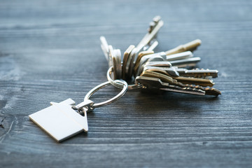 Bunch of keys with house shaped key ring on a wooden table