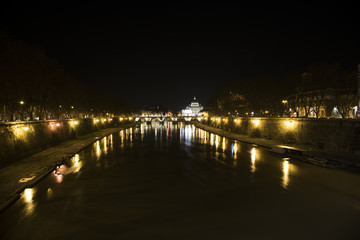 from a bridge over the Tiber river you can see the dome of St. Peter and bridge Vittorio Emanuele II