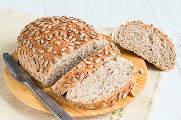  Rye bread with cereals.  Rye bread with cereals on a cutting board on a light wooden background.