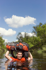 Man crossing the river with a backpack.