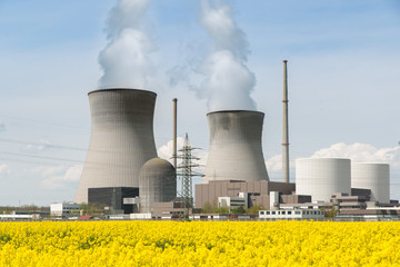 Nuclear power plant with yellow field and big blue clouds.