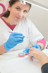 Closeup shot of a woman in a nail salon receiving a manicure.
