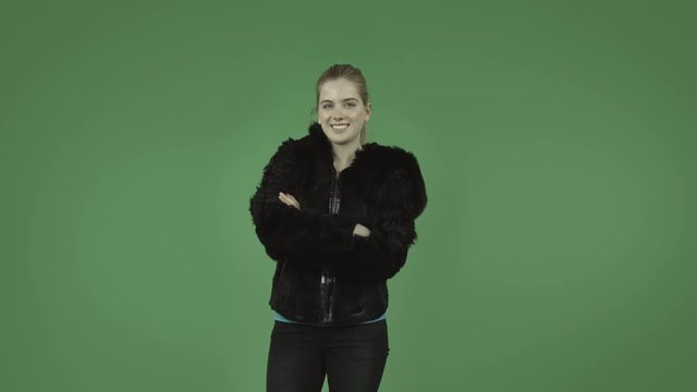 attractive caucasian girl with coat isolated on green confident