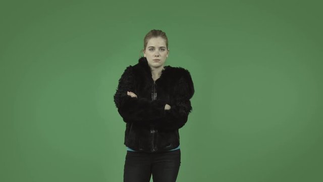attractive caucasian girl with coat isolated on green upset anger