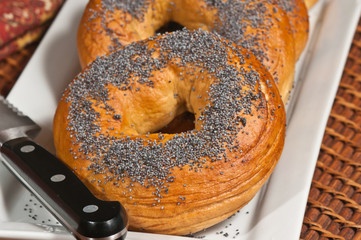 Hot and fresh bagels on a white plate with a knife