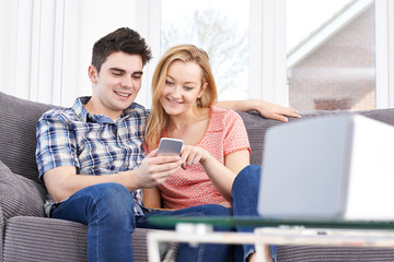 Couple Streaming Music From Mobile Phone To Wireless Speaker