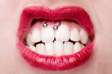 Naklejka premium Smiley Piercing Detail with Snarling Woman's Mouth