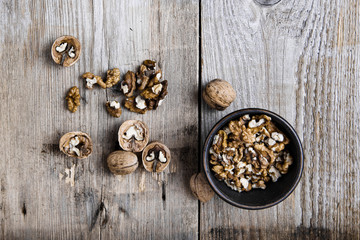 walnuts in a clay plate on a wooden background. top view