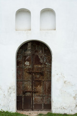 Fototapeta na wymiar Ancient rusty metallic door with rounded top