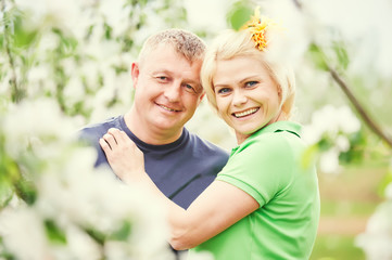 smiling adult couple in love. Blossoming tree garden