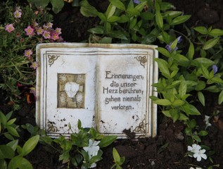 Geschmücktes Grab mit Trauerspruch