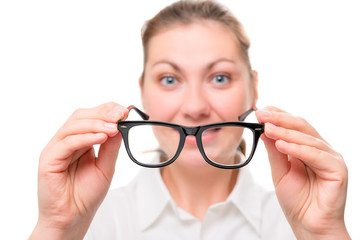 woman with poor eyesight wears glasses, focus on glasses