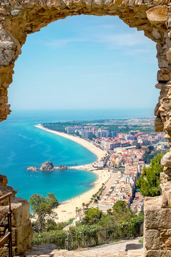 Beach and village Blanes through a stone arch. Costa Brava, Spai