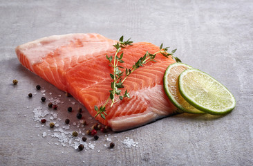 Fresh raw salmon fillet with lime, rosemary, pepper and salt