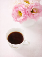 Still life with cup of coffee and flowers (Eustoma). Selective focus. Shallow depth of field. Added paper texture