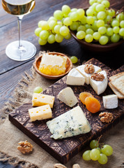 White wine in glass with cheese, honey, nuts and grape