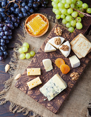Assortment of cheese with honey, nuts and grape