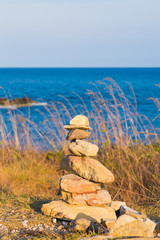 Stack of stones on beach with blue skyline background