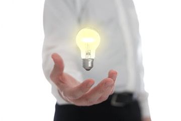Naklejka na ściany i meble Hand holding levitating light bulb representing an idea