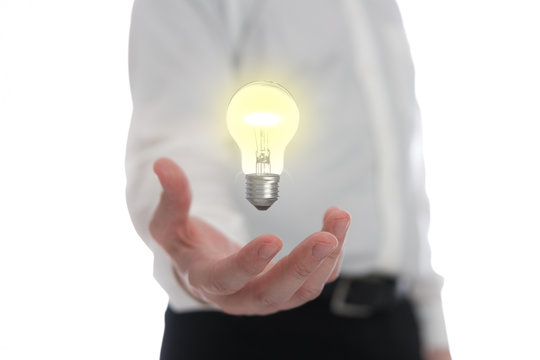 Hand holding levitating light bulb representing an idea