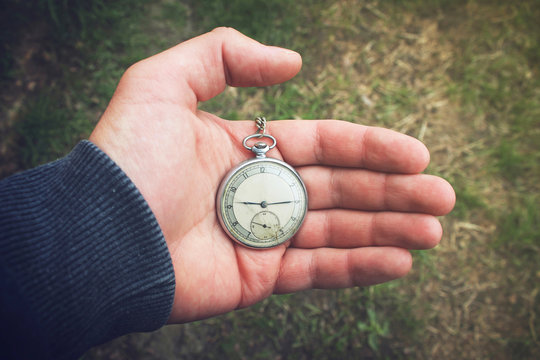 Old pocket watch in a man's hand