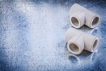 Plastic T-tube fittings on metallic background construction conc