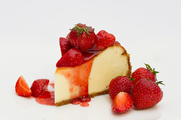 Slice cheesecake with fresh strawberries on white plate