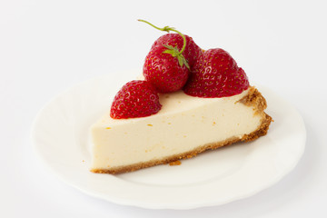 Slice cheesecake with fresh strawberries on white plate