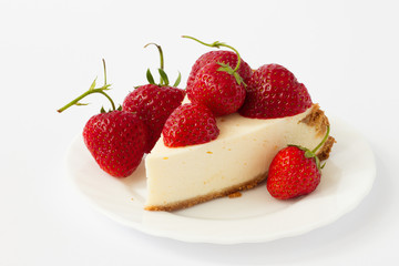 Slice cheesecake with fresh strawberries on white plate
