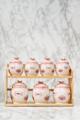 Ceramic Round Jars with Flower Ornaments  on White Wooden Background