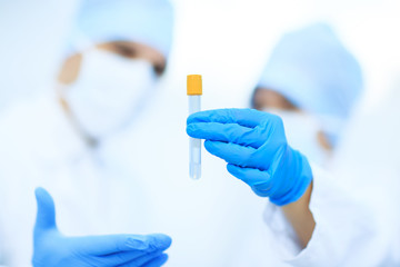 Two chemists are analyzing a liquid mixture in a test tube.