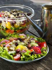 Greek salad in a glass container on the old wooden table