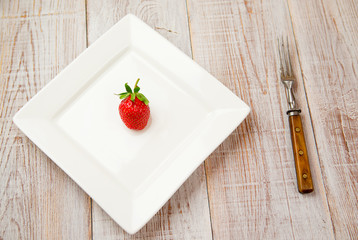 Ripe strawberry fruit on a white plate