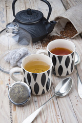 two cups 1 black tea rooibos and other fennel with teapot in the