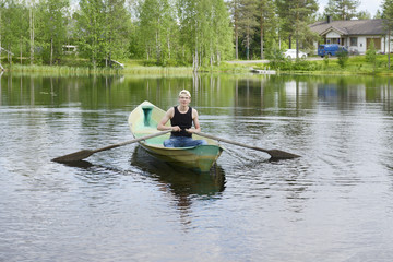 Fototapeta na wymiar Young man rowing a boat on a lake