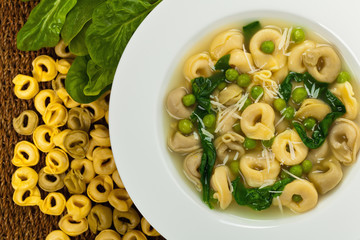 Tortellini Soup with Peas and Spinach. Selective focus.