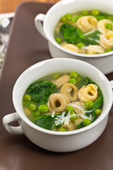 Tortellini Soup with Peas and Spinach. Selective focus.